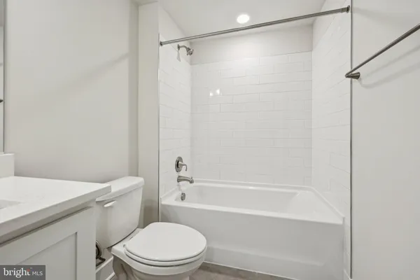 a white toilet and tub sitting next to a bathroom sink