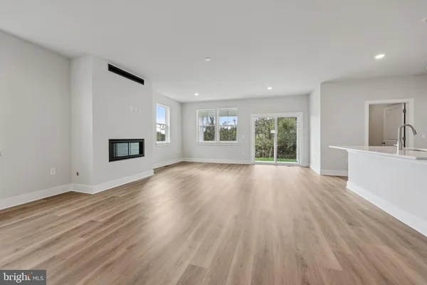 a view of empty room with wooden floor and fireplace