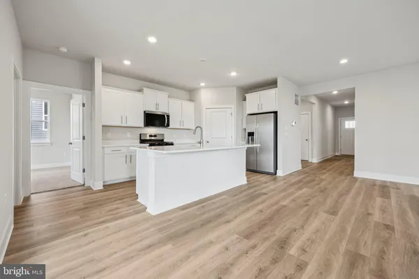 a view of kitchen with granite countertop cabinets and refrigerator