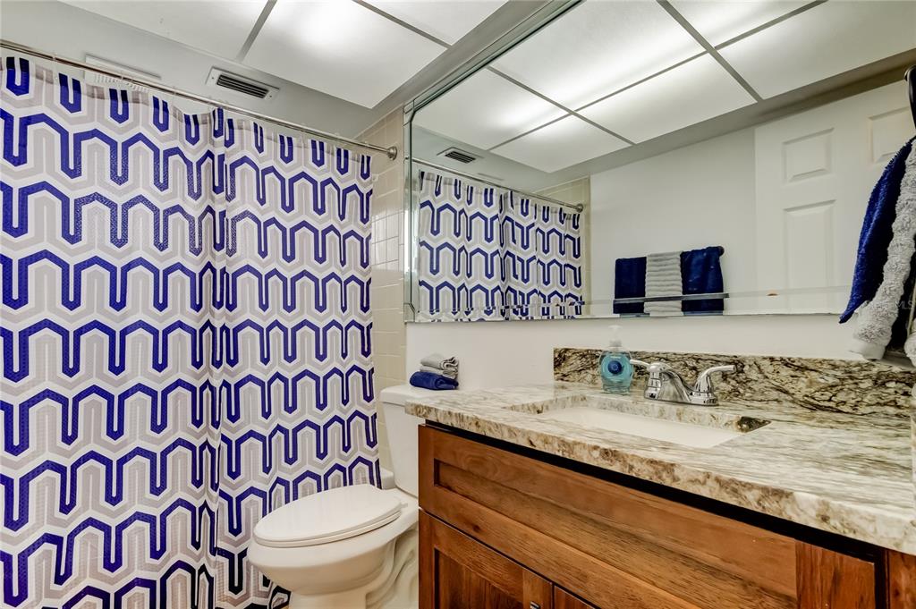 3625 Delta Place Holiday, FL 34691 - Photo 15 of 48 a bathroom with a granite countertop sink a toilet and a mirror