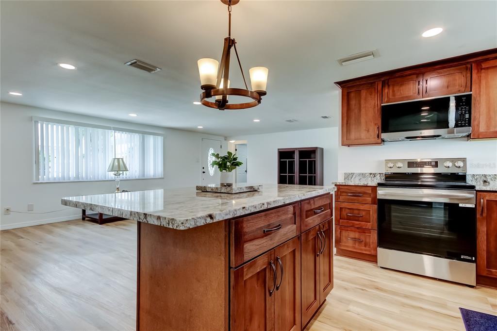 3625 Delta Place Holiday, FL 34691 - Photo 4 of 48 a kitchen with stainless steel appliances granite countertop a stove top oven a sink a counter space and cabinets