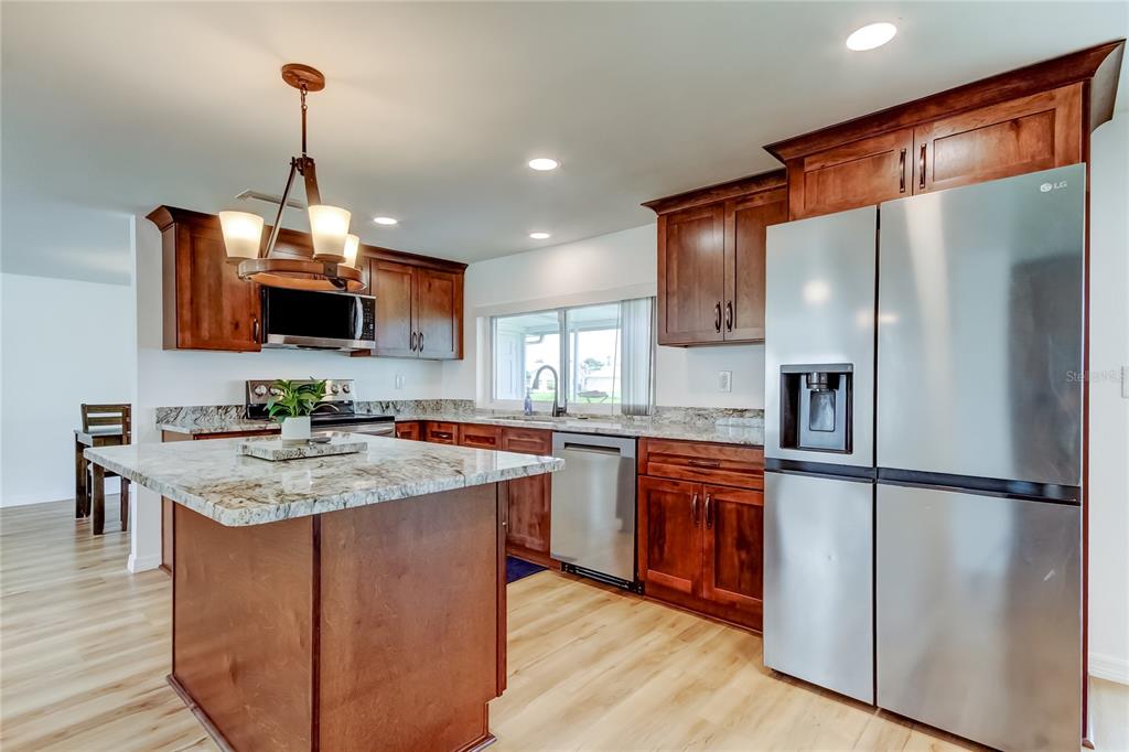 3625 Delta Place Holiday, FL 34691 - Photo 5 of 48 a kitchen with stainless steel appliances granite countertop a refrigerator a stove top oven a sink and dishwasher