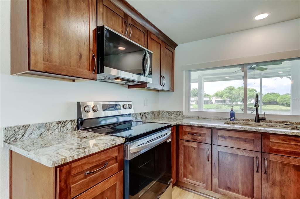3625 Delta Place Holiday, FL 34691 - Photo 6 of 48 a kitchen with stainless steel appliances granite countertop a sink and a microwave