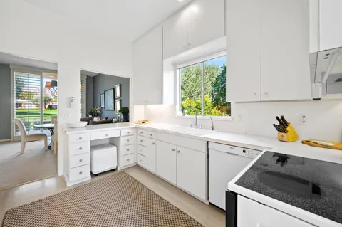 a hall with a sink cabinets and window