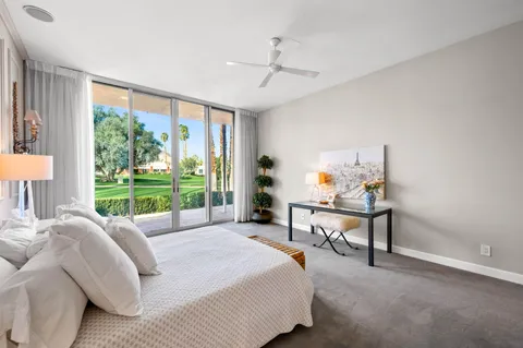 a bedroom with a bed and a large window