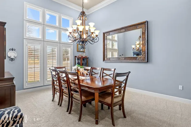a dining room with furniture a chandelier and a window