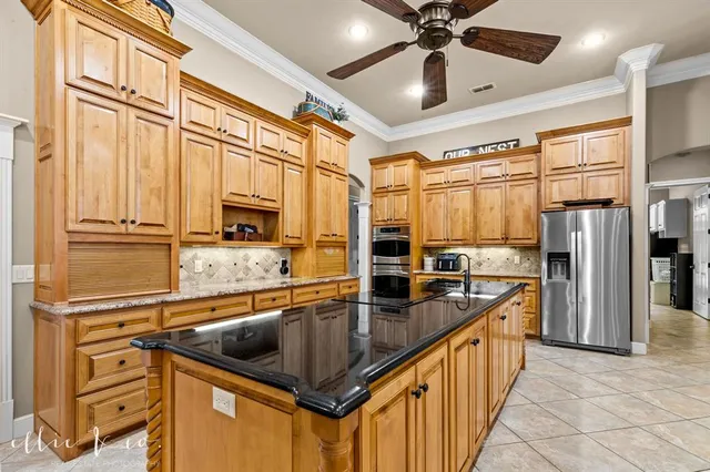 a kitchen with stainless steel appliances granite countertop a sink and a refrigerator