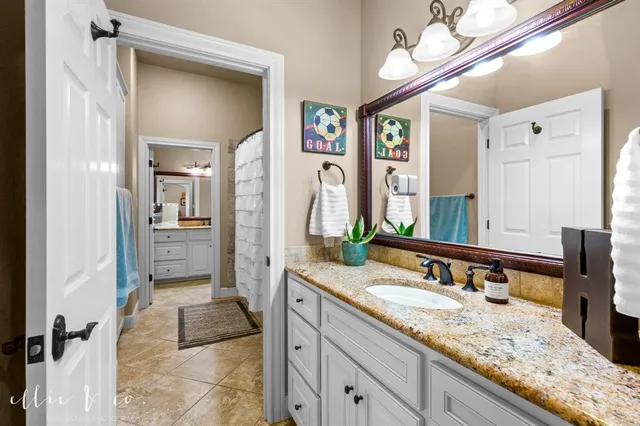 a bathroom with a granite countertop sink a mirror and a shower