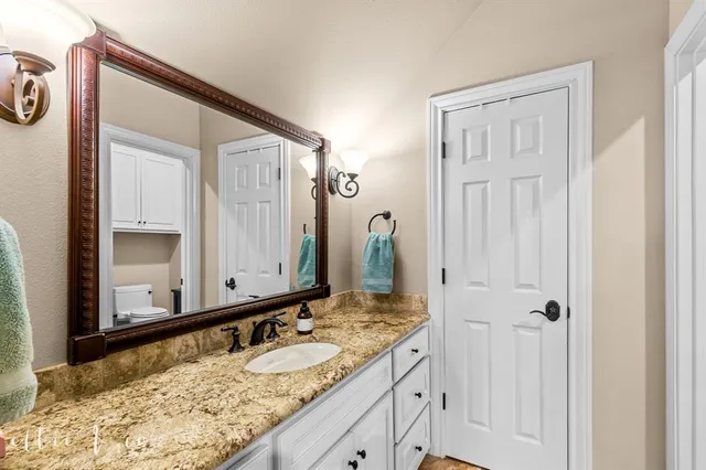 a bathroom with a granite countertop sink and a mirror