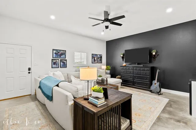 a living room with furniture and a view of kitchen