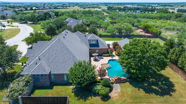 an aerial view of a house with a garden and lake view