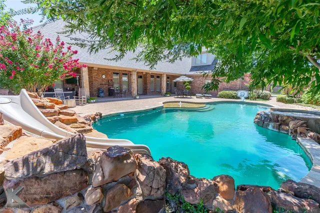 a front view of a house with swimming pool garden and patio