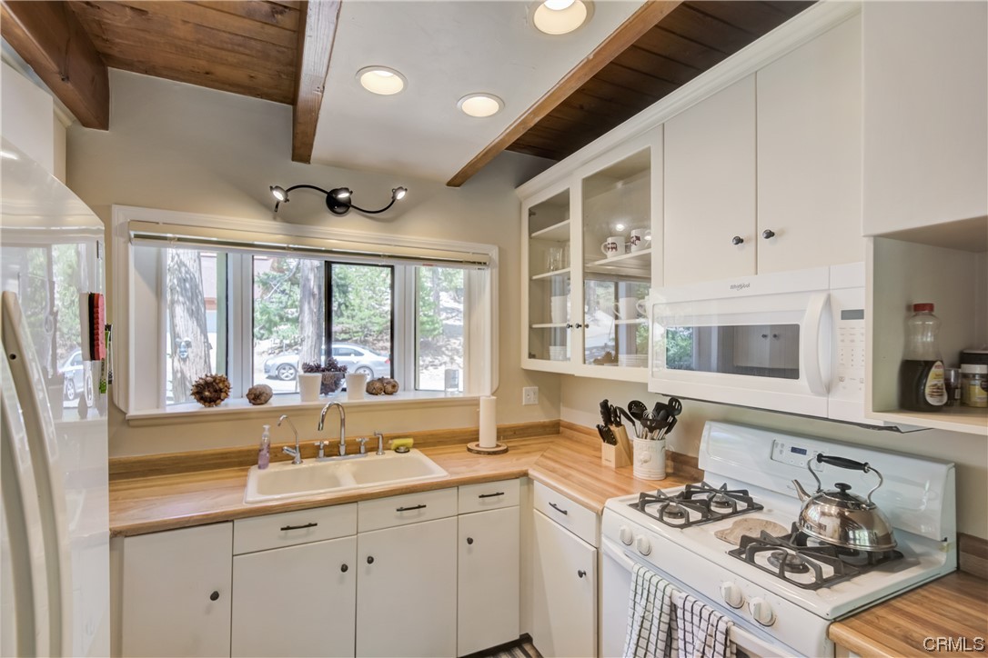 1017 Burnt Mill Road Lake Arrowhead, CA 92352 - Photo 11 of 32 a kitchen with a sink stove and cabinets