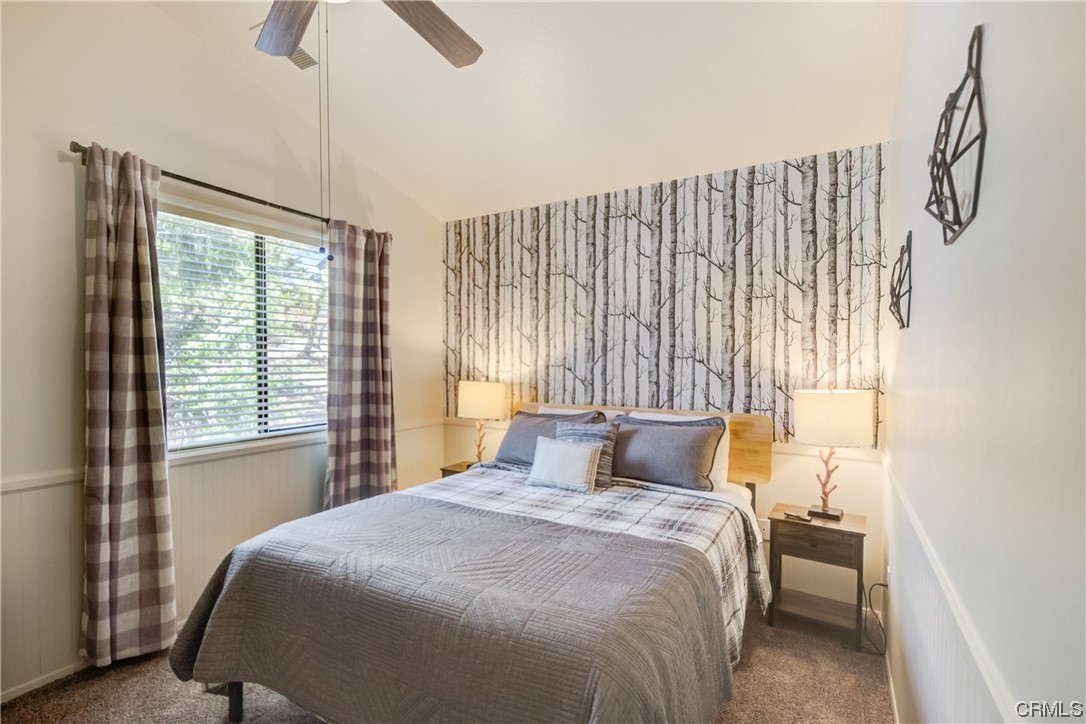 1017 Burnt Mill Road Lake Arrowhead, CA 92352 - Photo 16 of 32 a bedroom with a large bed and a chandelier