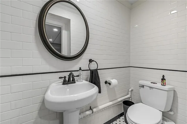 a bathroom with a toilet sink and mirror