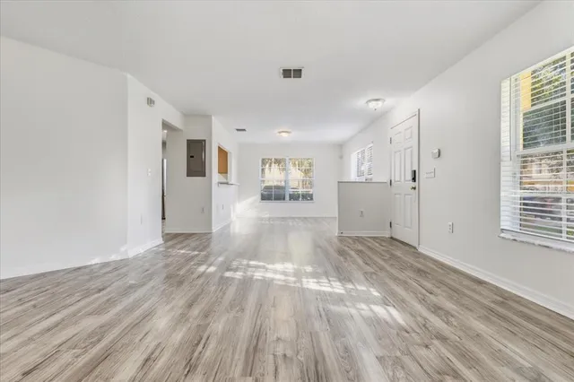 a view of a hallway with wooden floor and a living room