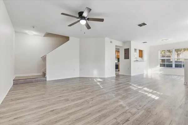 a view of a livingroom with wooden floor and ceiling fan