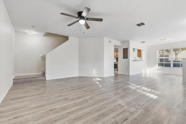 a view of a livingroom with wooden floor and ceiling fan