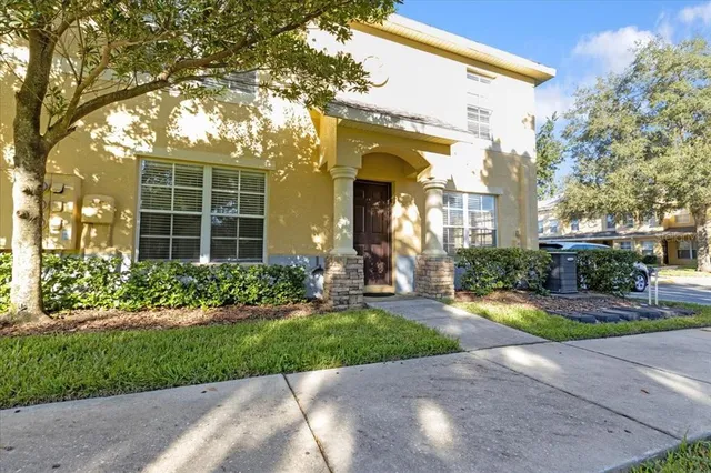 a front view of a house with a yard and potted plants