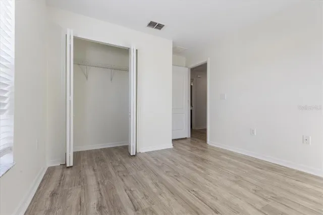 an empty room with wooden floor and closet