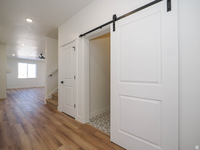 3938 North Wood Road Eagle Mountain, UT 84005 - Photo 8 of 55 Corridor with a barn door, recessed lighting, and light wood-type flooring