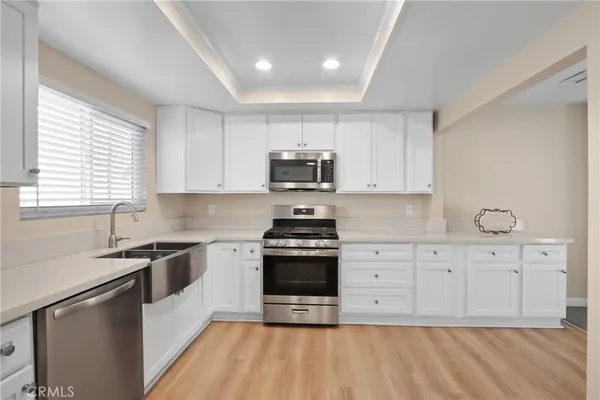 a kitchen with granite countertop white cabinets and stainless steel appliances