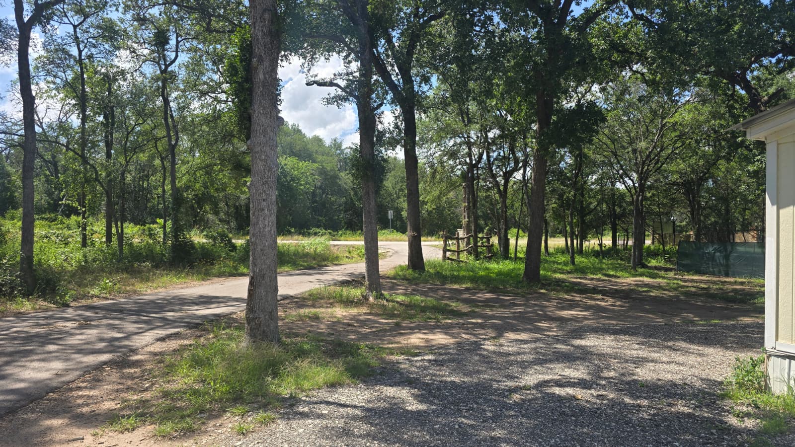 8607 Burleson Manor Road, Unit A Manor, TX 78653 - Photo 10 of 13 Mature trees frame a quiet road, creating a secluded and natural setting for this property.