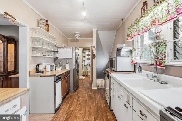 a kitchen with stainless steel appliances a stove and white cabinets