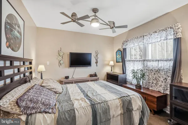 a bedroom with a bed a flat screen tv and a window