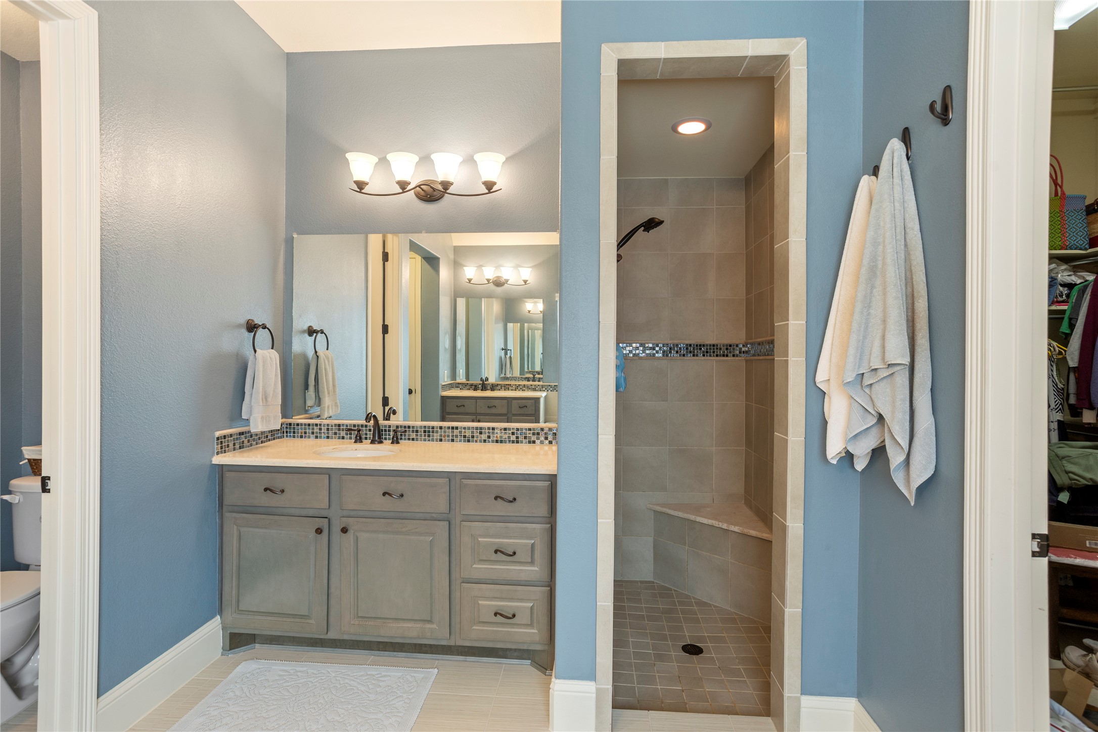17610 Astrachan Road Richmond, TX 77407 - Photo 16 of 25 a bathroom with a double vanity sink mirror and shower