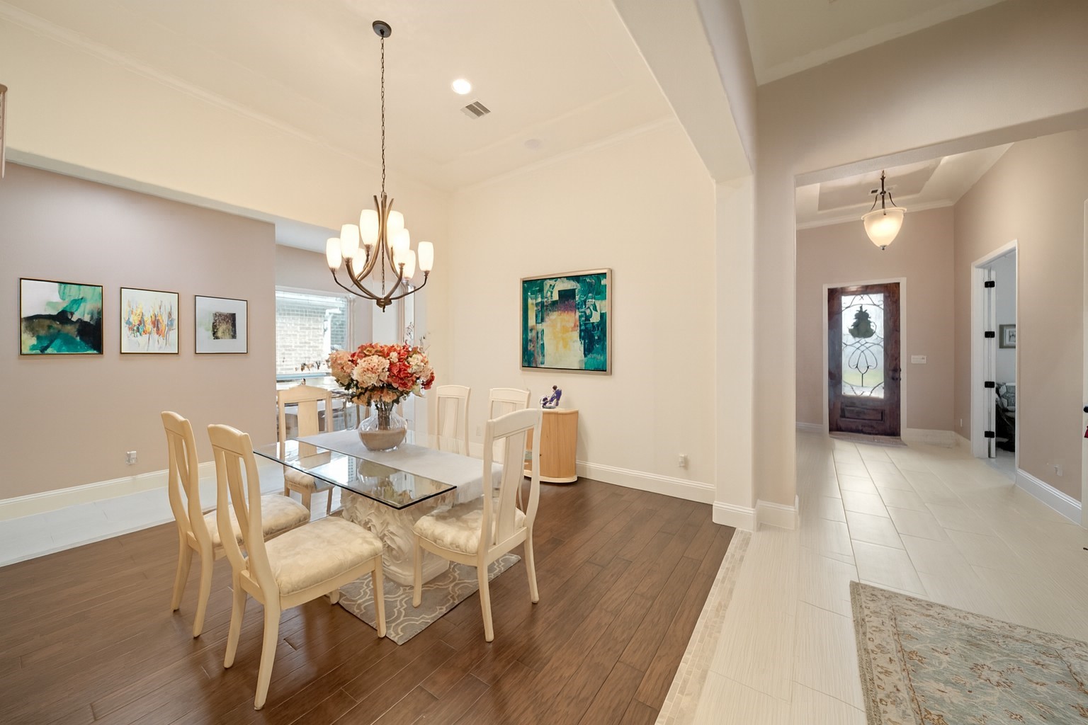 17610 Astrachan Road Richmond, TX 77407 - Photo 5 of 25 a dining room with wooden floor a chandelier a wooden table and chairs