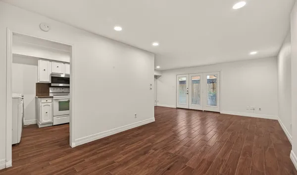 a view of empty room with wooden floor