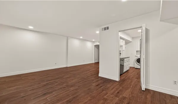 a view of a room with wooden floor and a ceiling fan