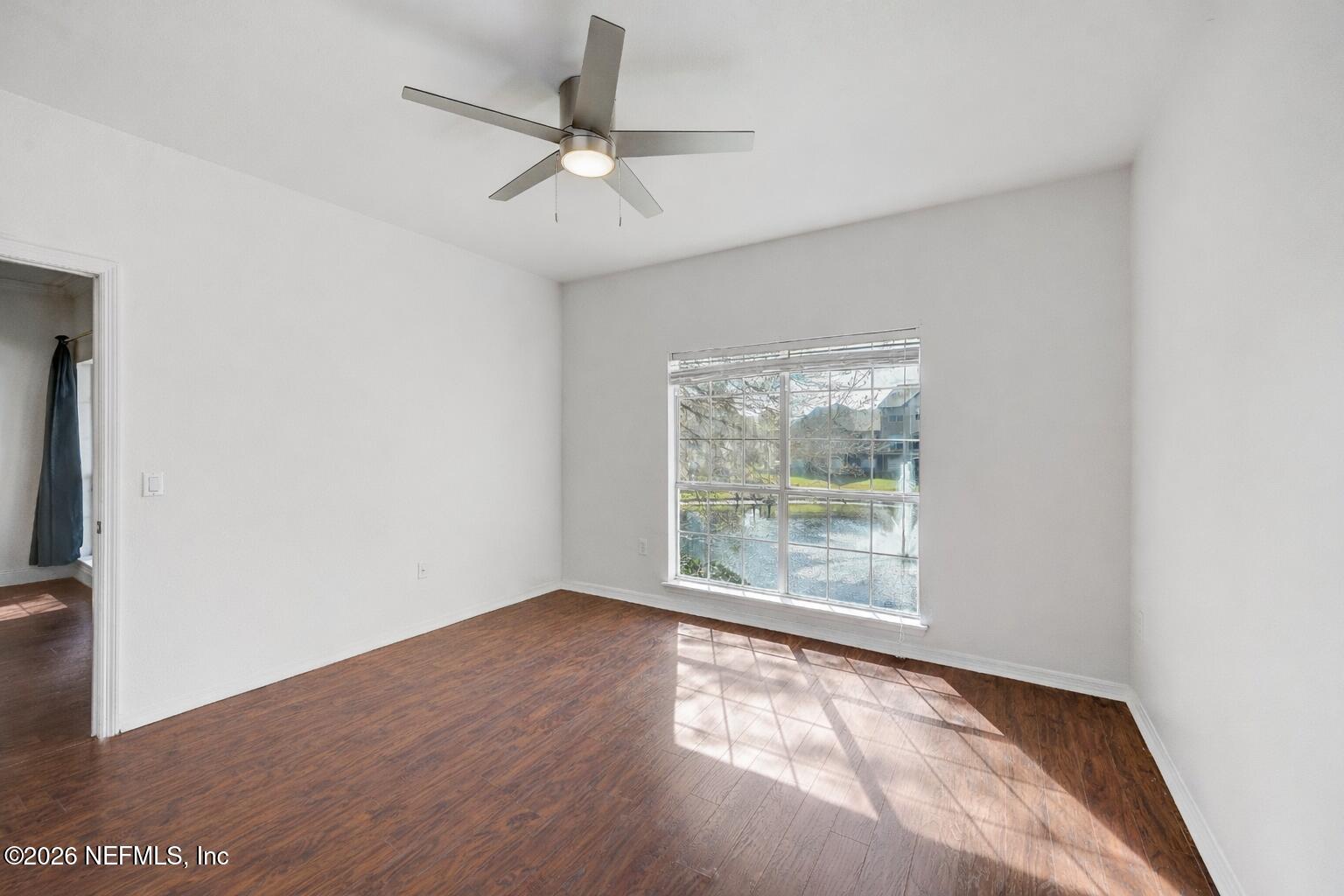 10961 Burnt Mill Road, Unit 824 Jacksonville, FL 32256 - Photo 11 of 35 an empty room with wooden floor fan and windows