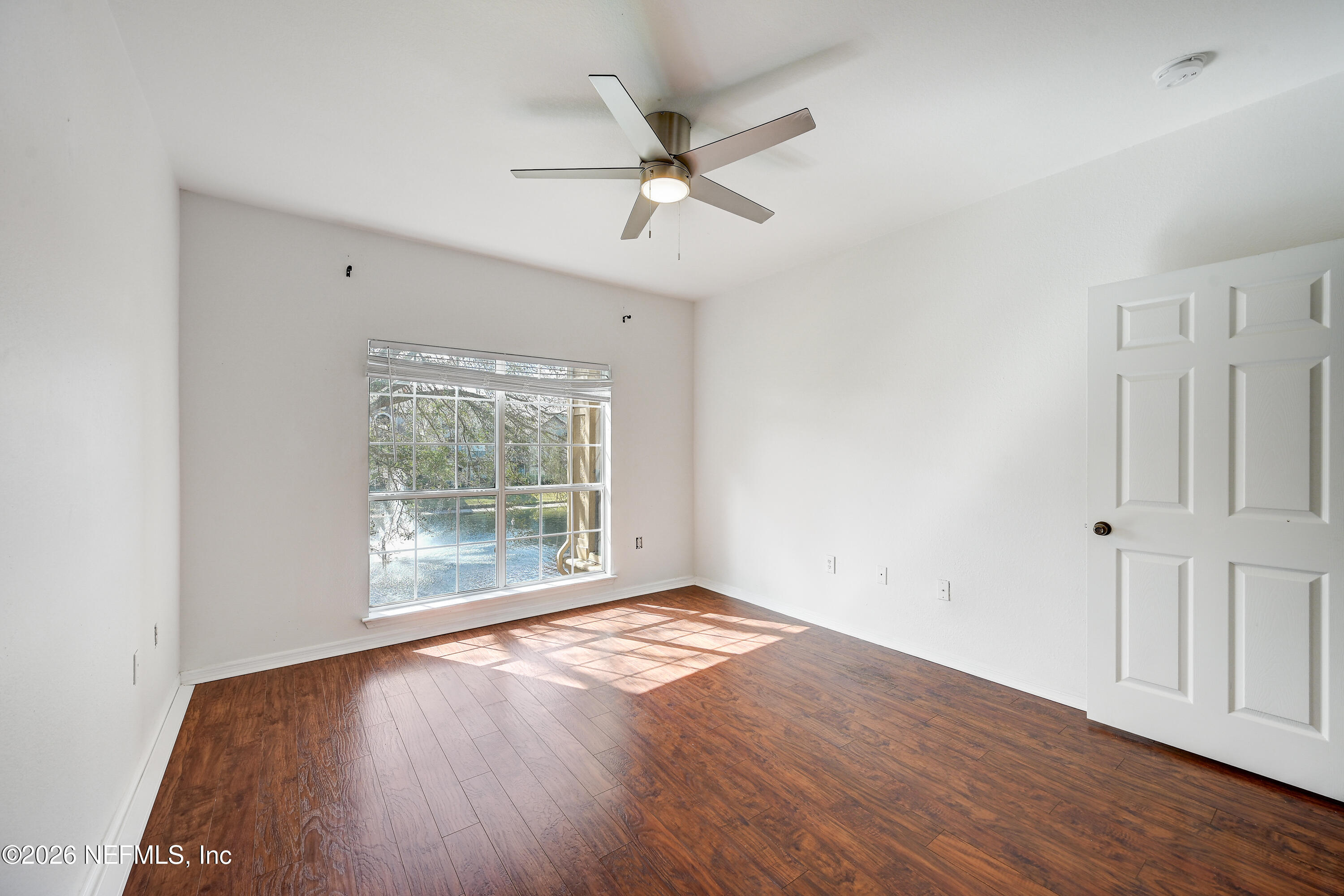 10961 Burnt Mill Road, Unit 824 Jacksonville, FL 32256 - Photo 15 of 35 an empty room with wooden floor fan and windows