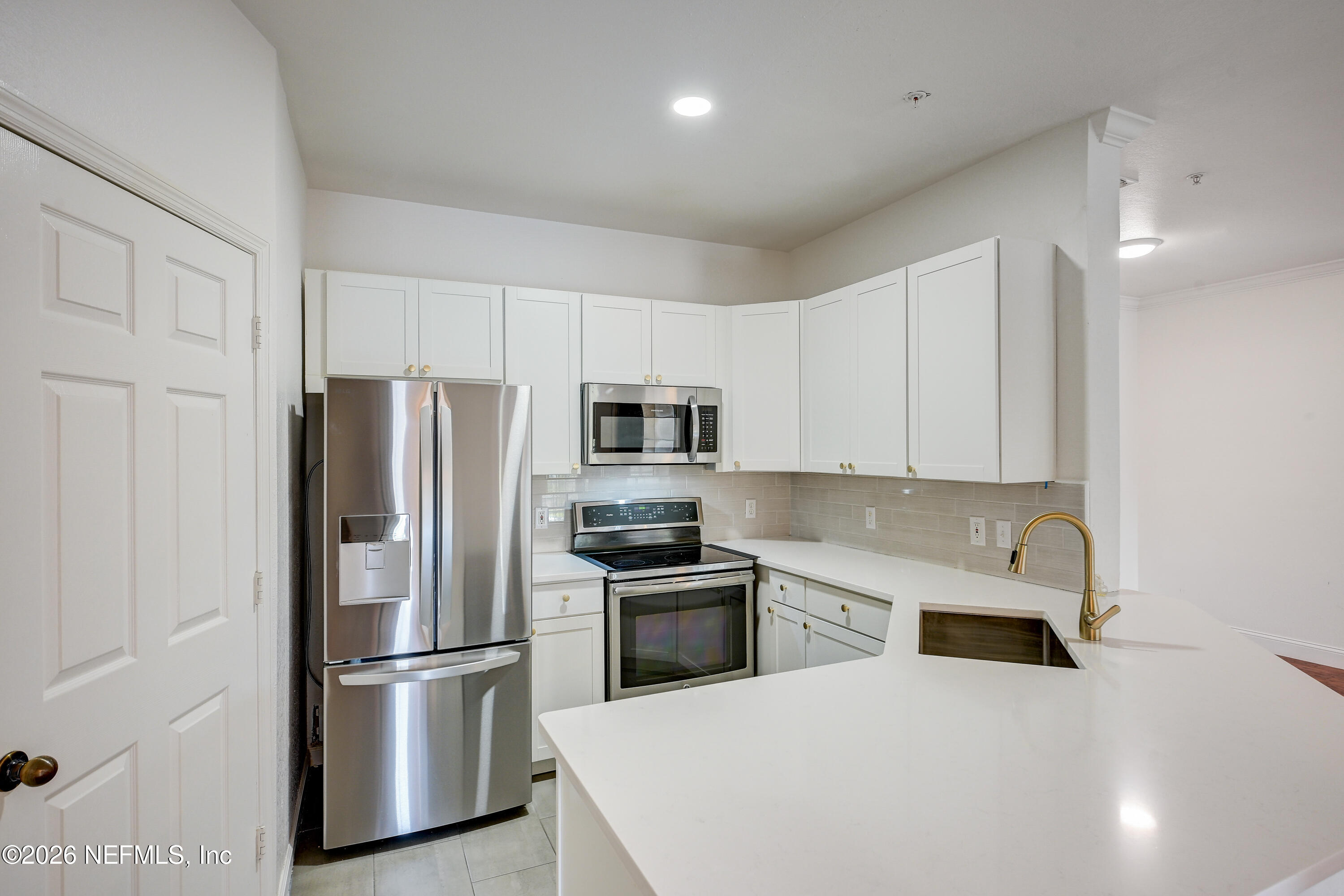 10961 Burnt Mill Road, Unit 824 Jacksonville, FL 32256 - Photo 4 of 35 a kitchen with stainless steel appliances a refrigerator sink and microwave