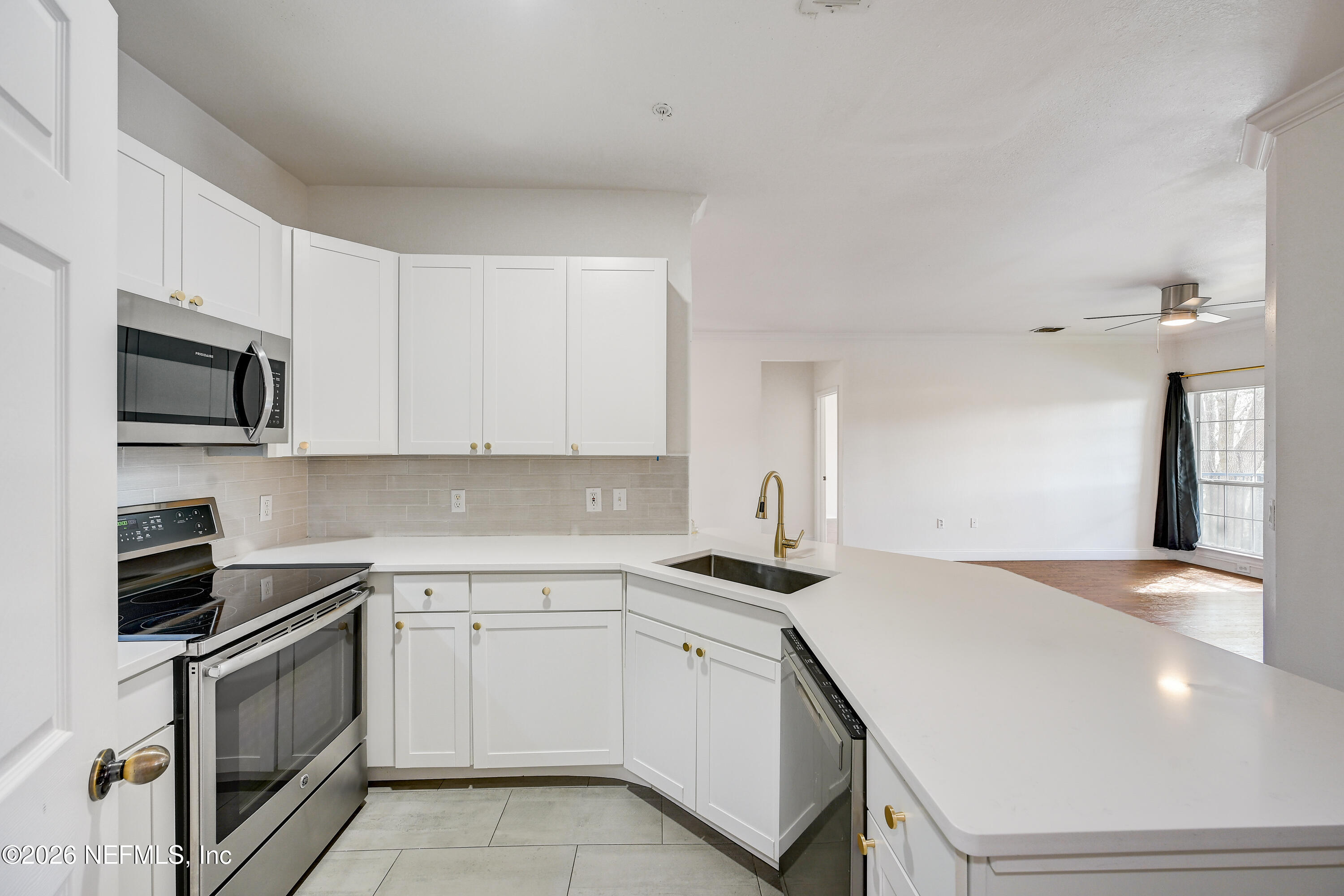 10961 Burnt Mill Road, Unit 824 Jacksonville, FL 32256 - Photo 5 of 35 a kitchen with white cabinets stainless steel appliances and sink