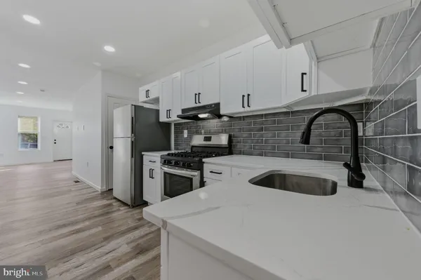 a kitchen with granite countertop a sink and a stove