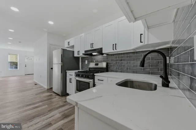 a kitchen with granite countertop a sink and a stove