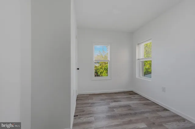 an empty room with window and mirror