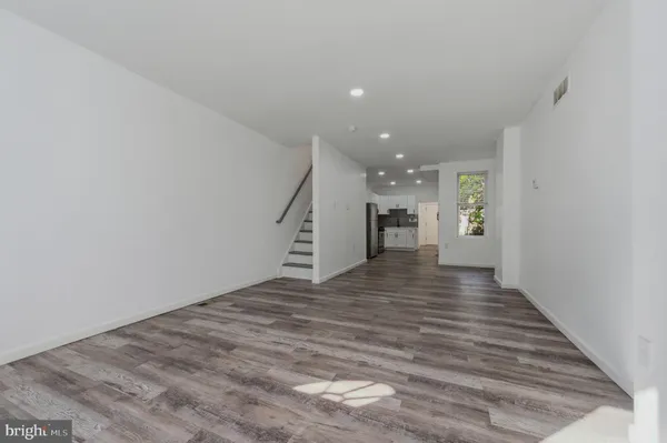 a view of an empty room with wooden floor