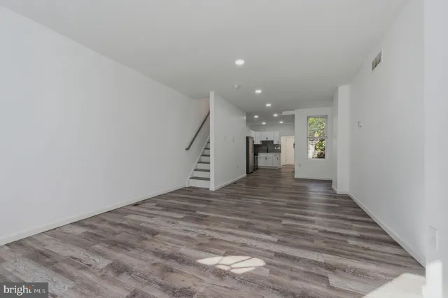a view of an empty room with wooden floor