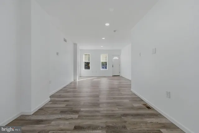 a view of a hallway with wooden floor