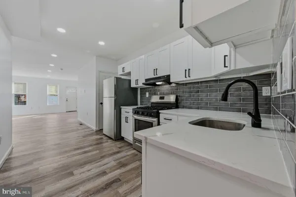 a kitchen with kitchen island stainless steel appliances a sink a stove and oven