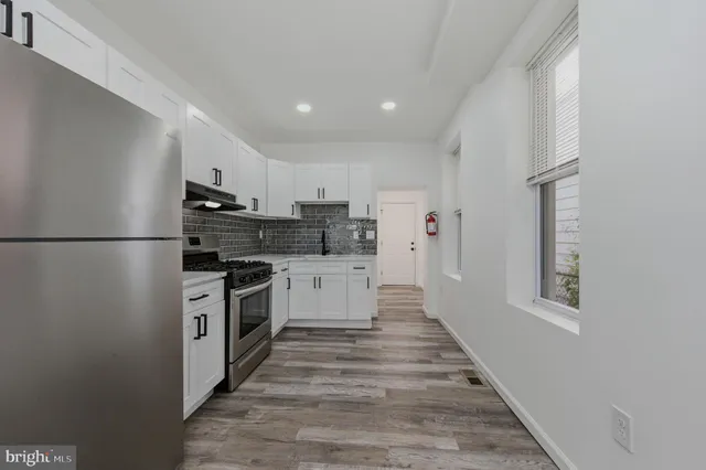 a kitchen with stainless steel appliances a refrigerator sink and cabinets
