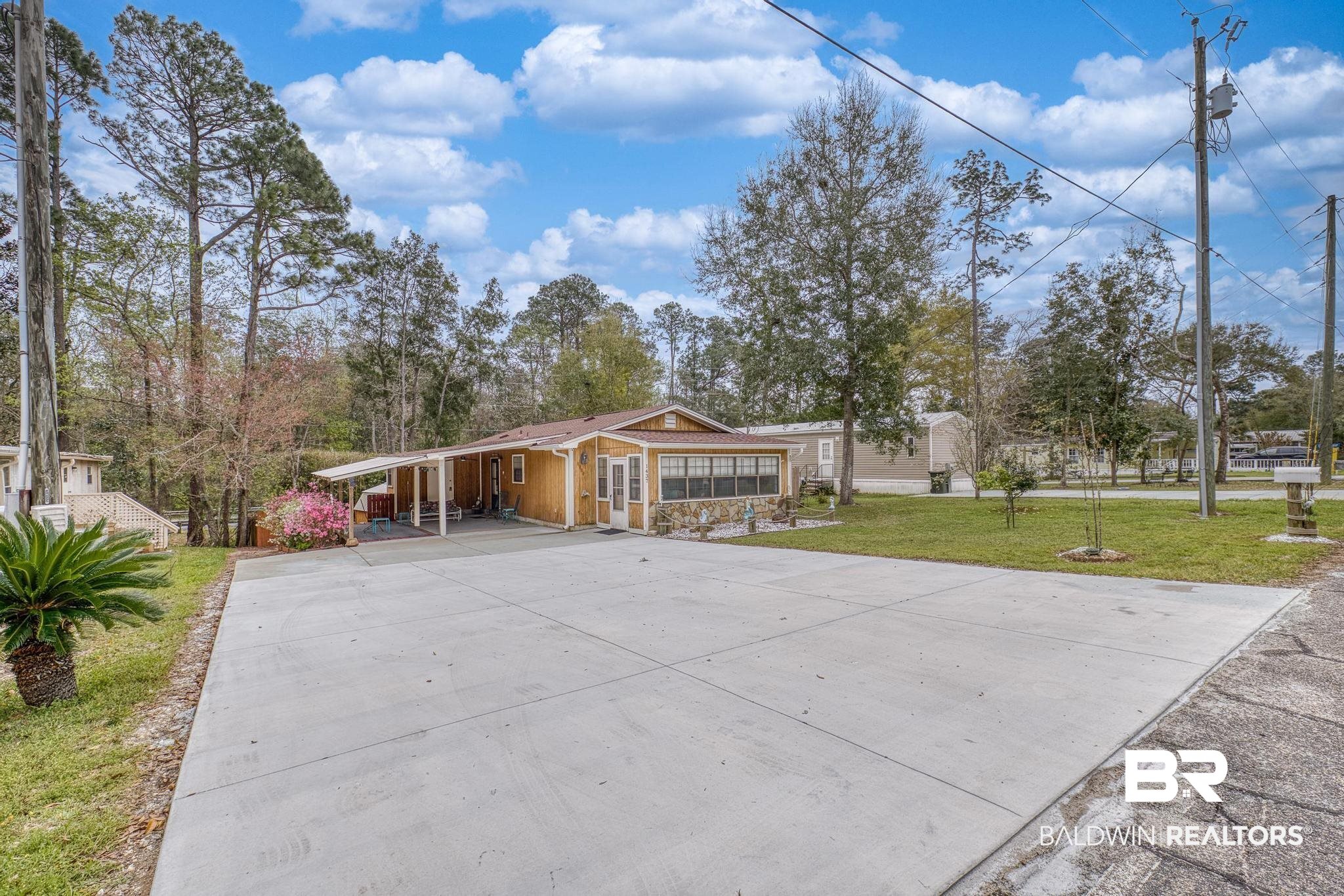 1437 Rio Circle Lillian, AL 36549 - Photo 27 of 46 View of front facade featuring a front yard, an attached carport, and concrete driveway