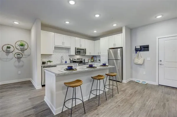 a kitchen with a refrigerator a stove top oven a sink and cabinets