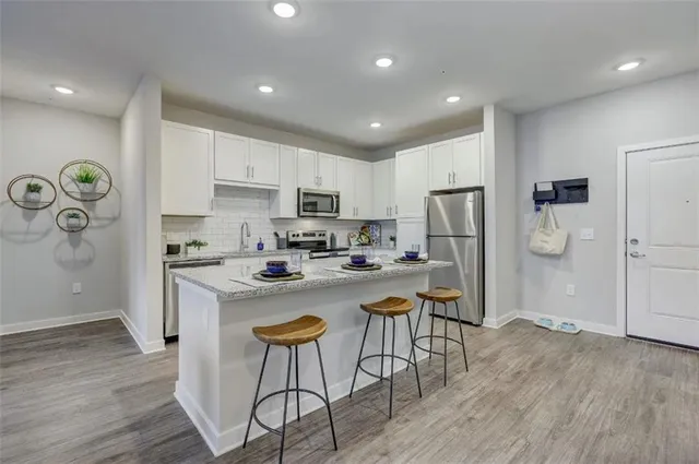a kitchen with a refrigerator a stove top oven a sink and cabinets