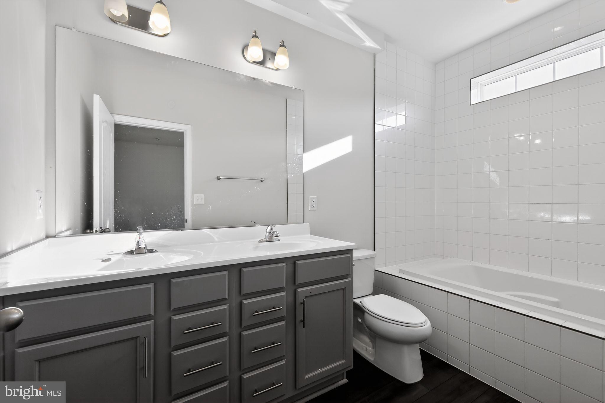 1027 Overlook Way Laurel, MD 20707 - Photo 23 of 30 a bathroom with a toilet a sink a mirror a bathtub and shower