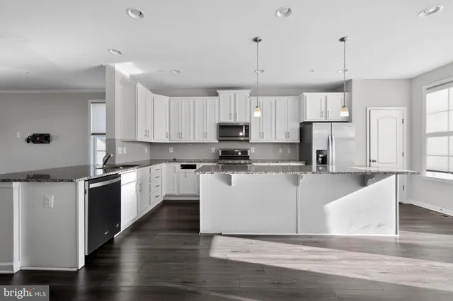 a large kitchen with cabinets and wooden floor